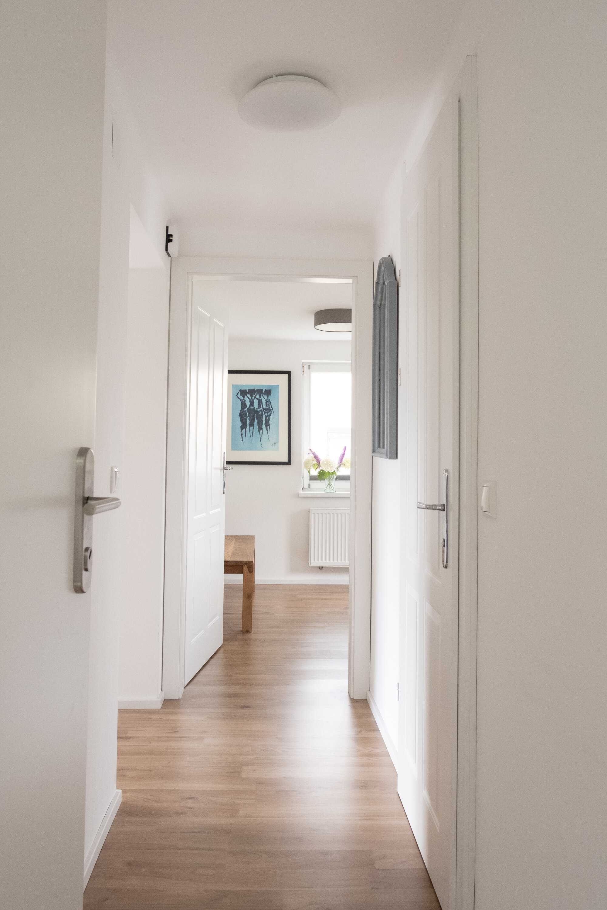 The cloakroom is located directly behind the entrance door. To the left is the open-plan living and dining area, straight ahead is the bedroom, and to the right is the modern bathroom.