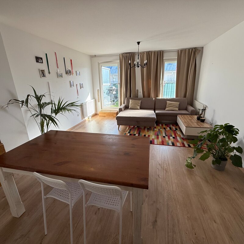 Bright living area with wood floors & lounge sofa – 3-room apartment, short-term rental Vienna, temporary housing 1–6 months