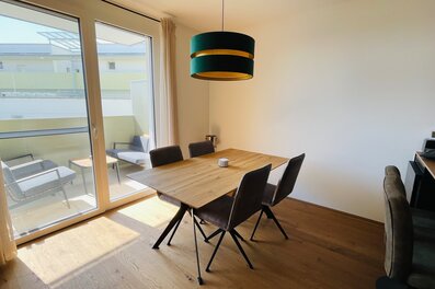 Heller Essbereich mit Holztisch, Designlampe & Balkon – 2-Zimmer Wohnung, Kurzzeitmiete Graz, Wohnen auf Zeit 1–6 Monate | © Philip Gruber