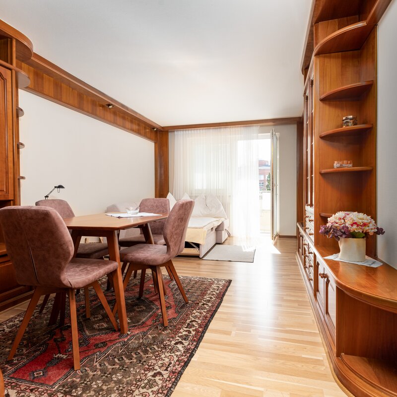 Bright living room with dining table & built-in units – 2-room apartment, short-term rental Salzburg, temporary housing 1 to 6 months