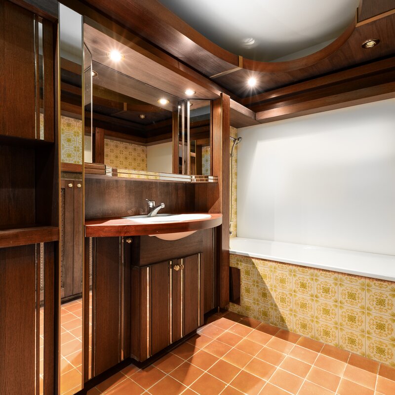 A functional bathroom with modern elements. Dark wood details add an elegant touch to the room.
