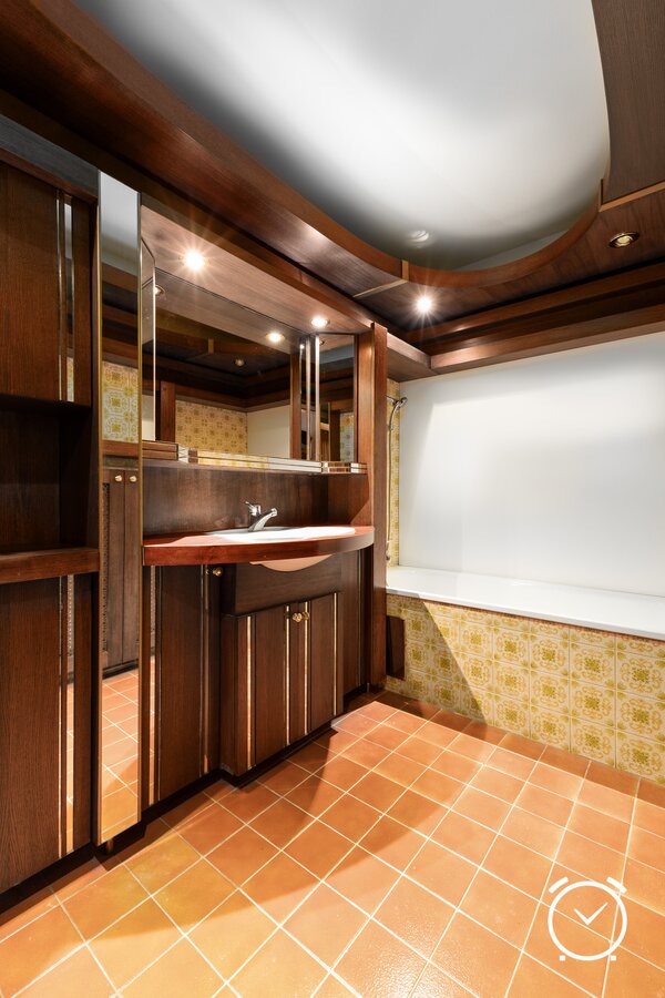 A functional bathroom with modern elements. Dark wood details add an elegant touch to the room.