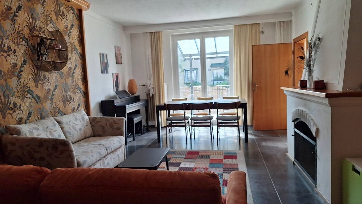 Wohnzimmer mit Kamin und Ausgang zur Terrasse