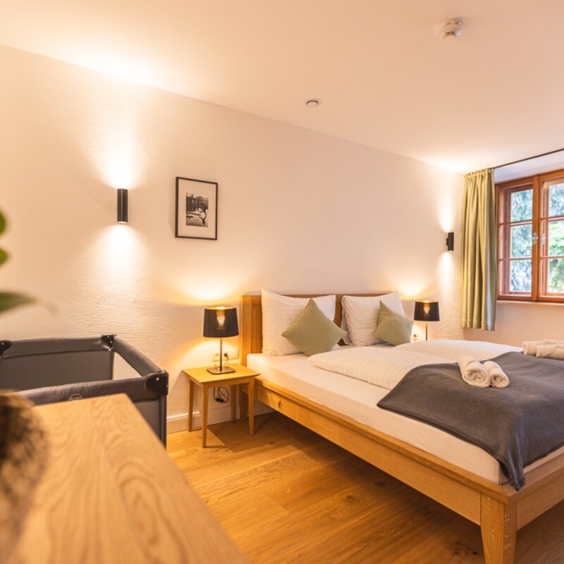 Helles Schlafzimmer mit Holzboden & Wandleuchten – 2-Zimmer-Apartment zur Kurzzeitmiete, Wohnen auf Zeit 1–6 Monate, Hallein | © Michael Kuschei