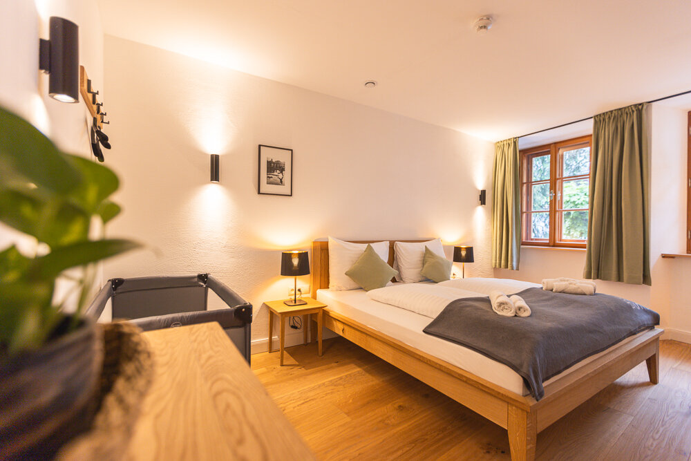 Helles Schlafzimmer mit Holzboden & Wandleuchten – 2-Zimmer-Apartment zur Kurzzeitmiete, Wohnen auf Zeit 1–6 Monate, Hallein | © Michael Kuschei