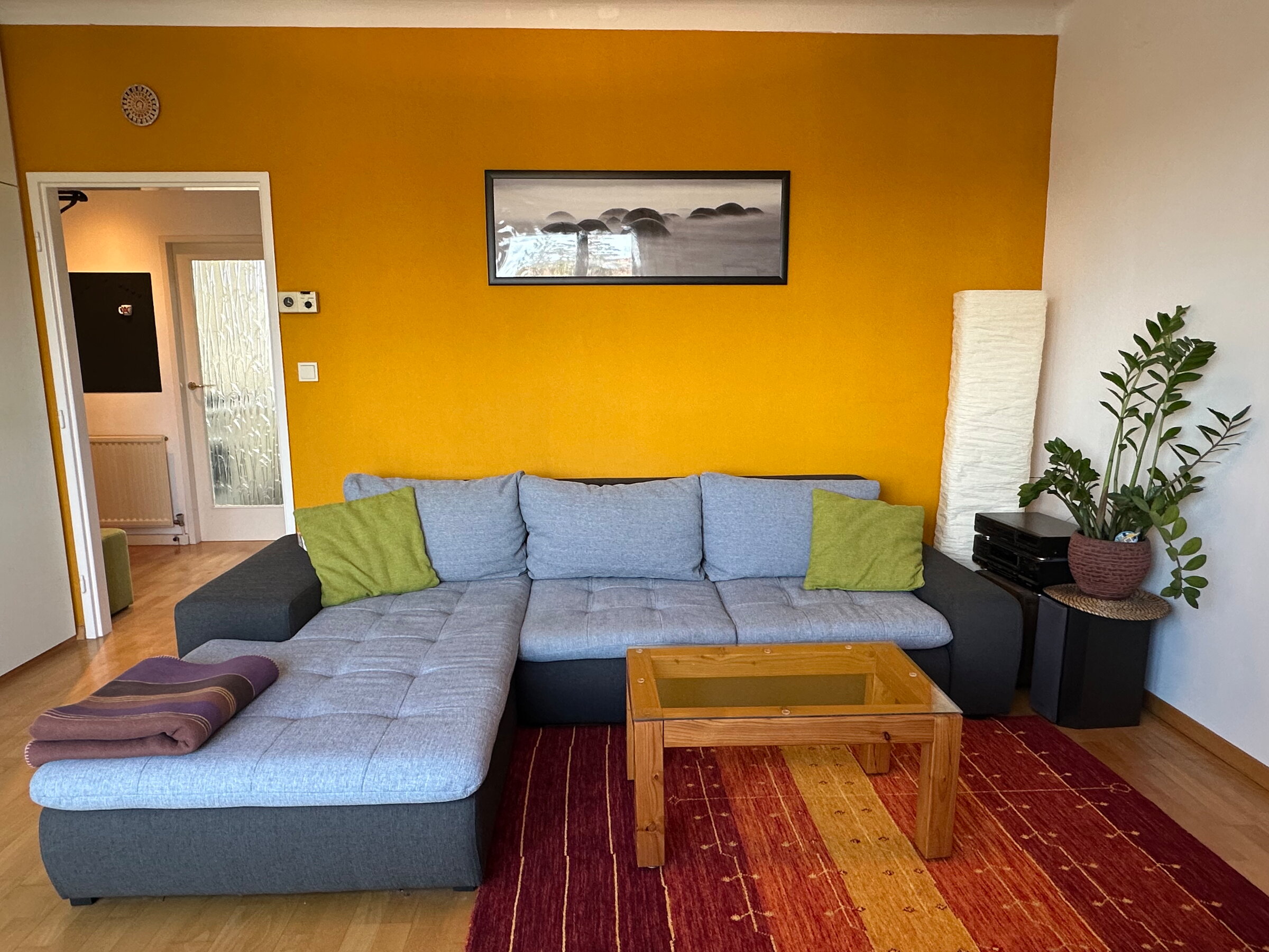 Helles Wohnzimmer mit Ecksofa & Akzentwand – 1-Zimmer Wohnung zur Kurzzeitmiete in Hietzing