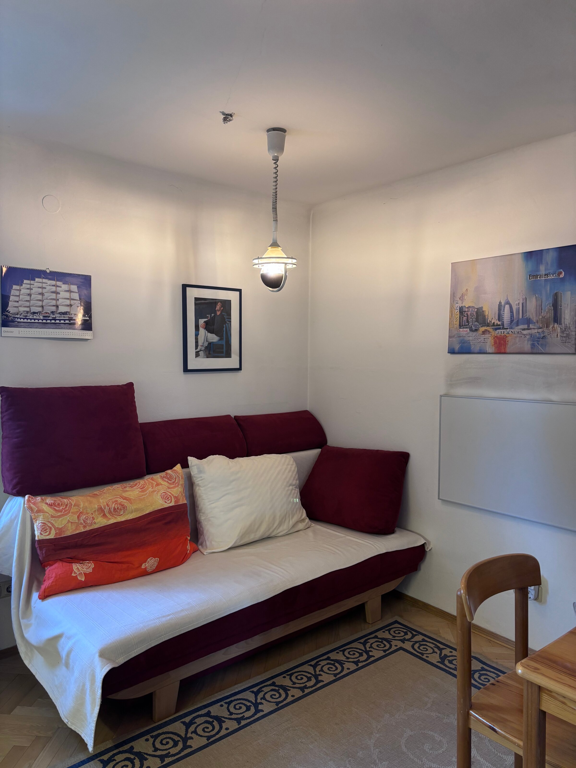 Das Schlafsofa befindet sich im Wohnzimmer. Auf der rechten Seite befindet sich ein Infrarot-Heizpanel