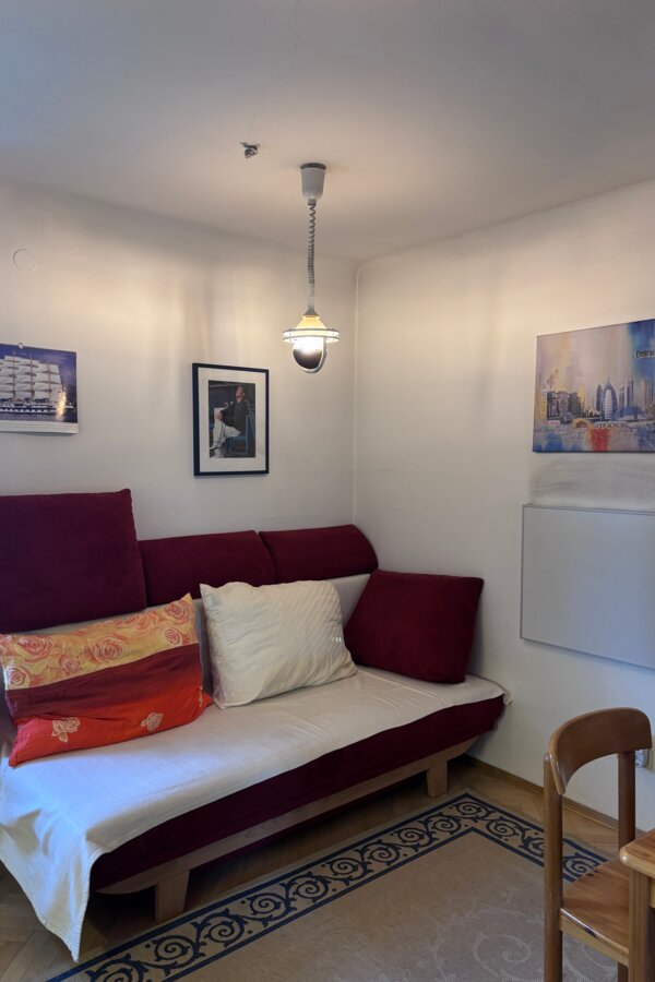 Das Schlafsofa befindet sich im Wohnzimmer. Auf der rechten Seite befindet sich ein Infrarot-Heizpanel