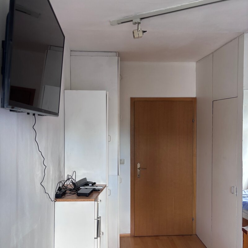 Die Tür führt ins Wohnzimmer, auf der rechten Seite befindet sich ein begehbarer Kleiderschrank.