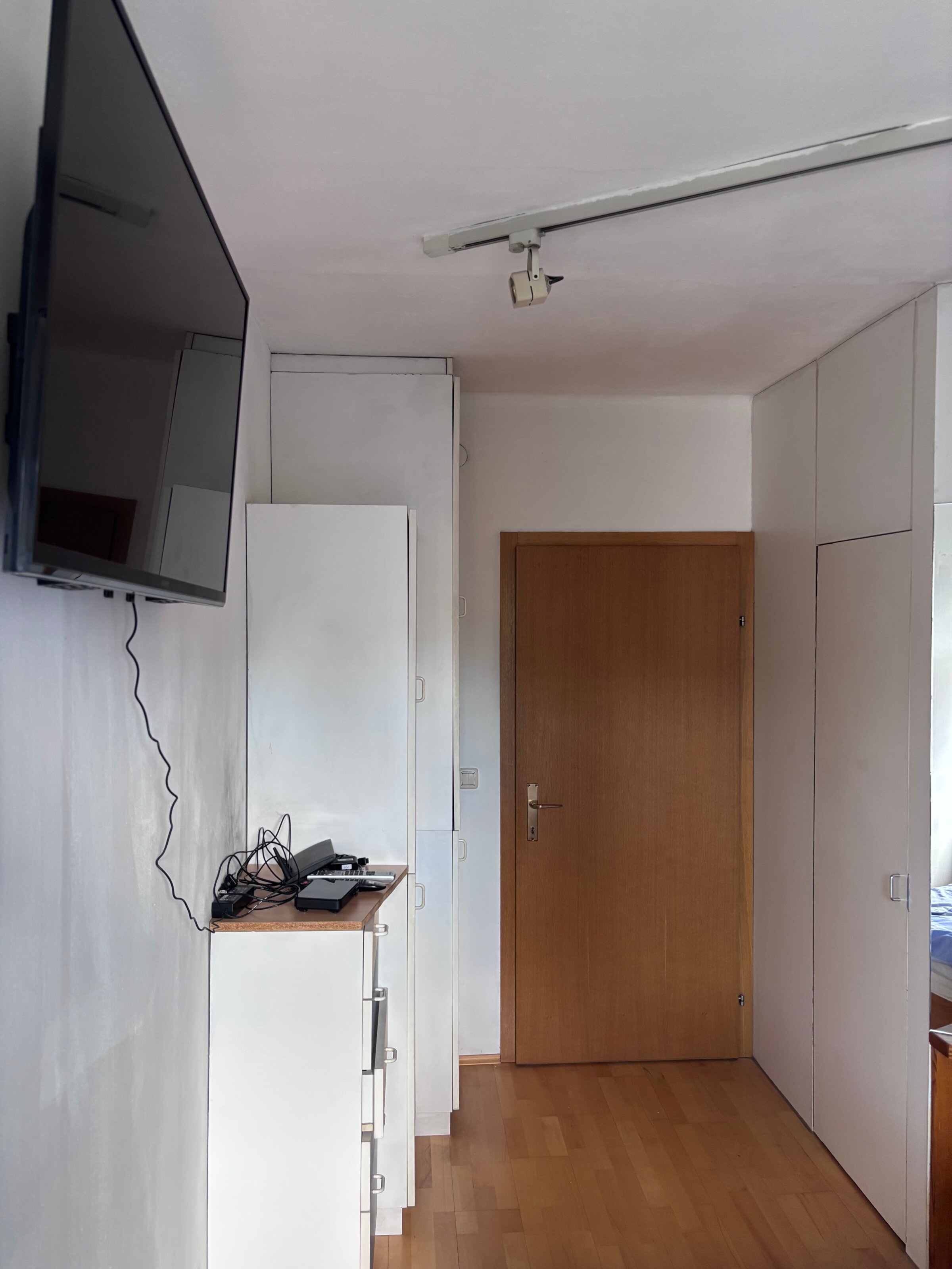 Die Tür führt ins Wohnzimmer, auf der rechten Seite befindet sich ein begehbarer Kleiderschrank.