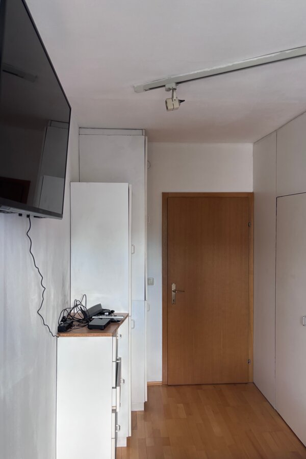 Die Tür führt ins Wohnzimmer, auf der rechten Seite befindet sich ein begehbarer Kleiderschrank.