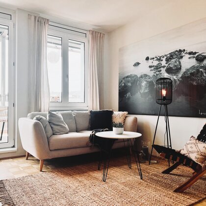 Heller Wohnbereich mit Sofa & Naturmaterialien – 1-Zimmer Apartment zur Kurzzeitmiete in Linz, Wohnen auf Zeit 1 bis 6 Monate | © Sabine Schöffmann