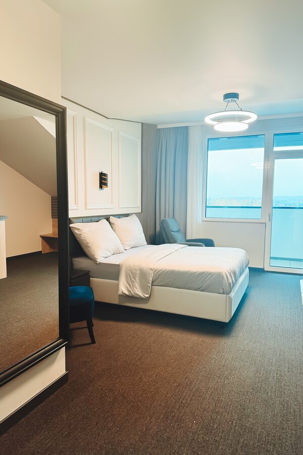 Helles Schlafzimmer mit Doppelbett & Panoramafenster – 1-Zimmer Suite zur Kurzzeitmiete, Wohnen auf Zeit für 1 bis 6 Monate in Hörsching