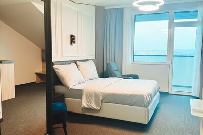 Helles Schlafzimmer mit Doppelbett & Panoramafenster – 1-Zimmer Suite zur Kurzzeitmiete, Wohnen auf Zeit für 1 bis 6 Monate in Hörsching