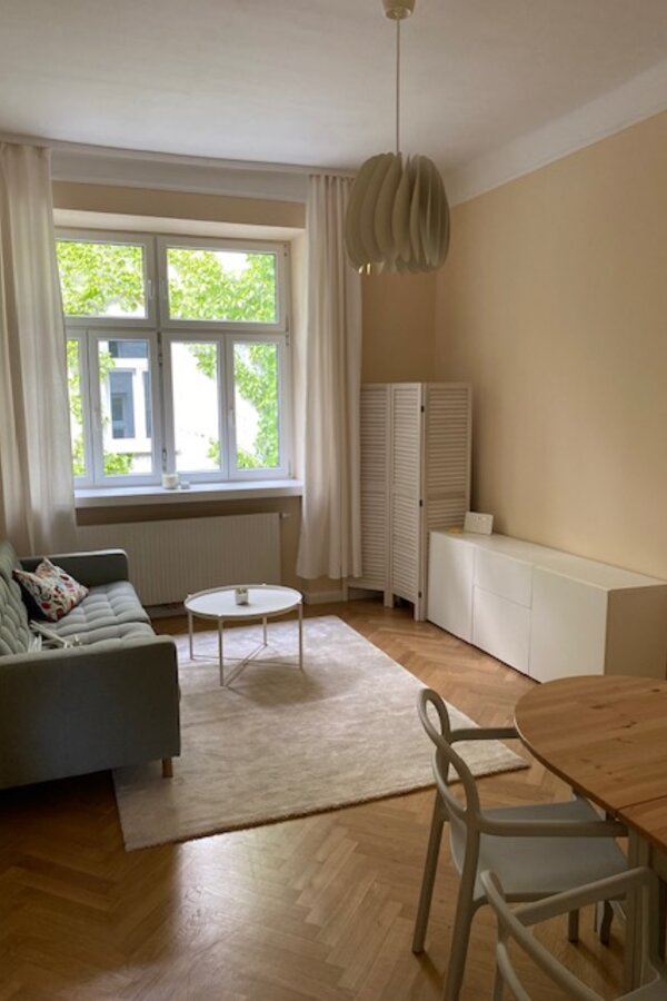 Wohnzimmer mit Blick in den begrünten Innenhof