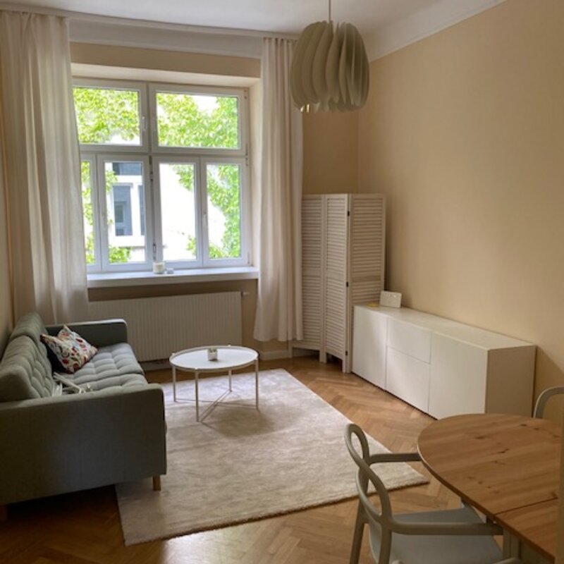 Wohnzimmer mit Blick in den begrünten Innenhof