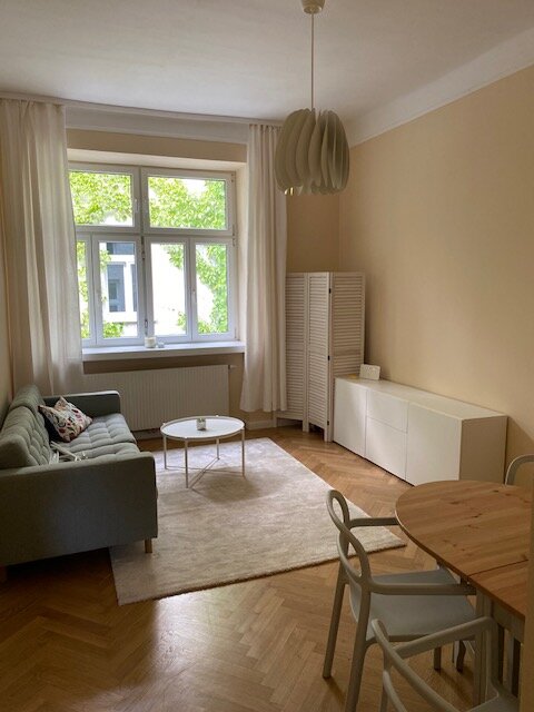 Wohnzimmer mit Blick in den begrünten Innenhof