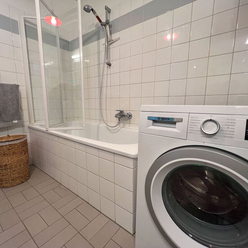 Spacious bathroom with bathtub and new washing machine | © A.S.