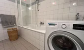 Spacious bathroom with bathtub and new washing machine | © A.S.