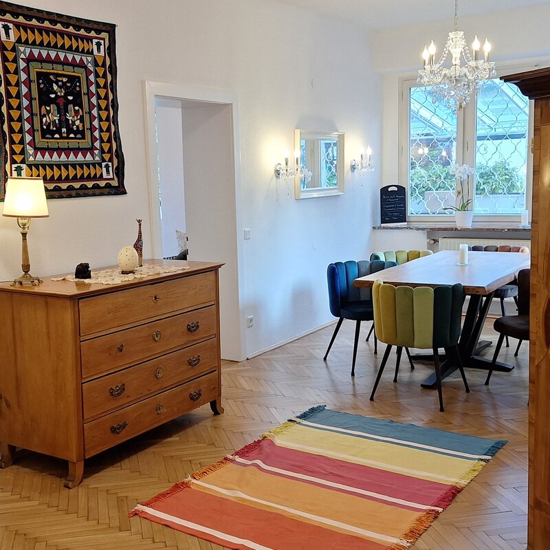 Bright living-dining room with herringbone parquet & chandelier – 4-room short-term rental, temporary housing Salzburg, 1–6 months