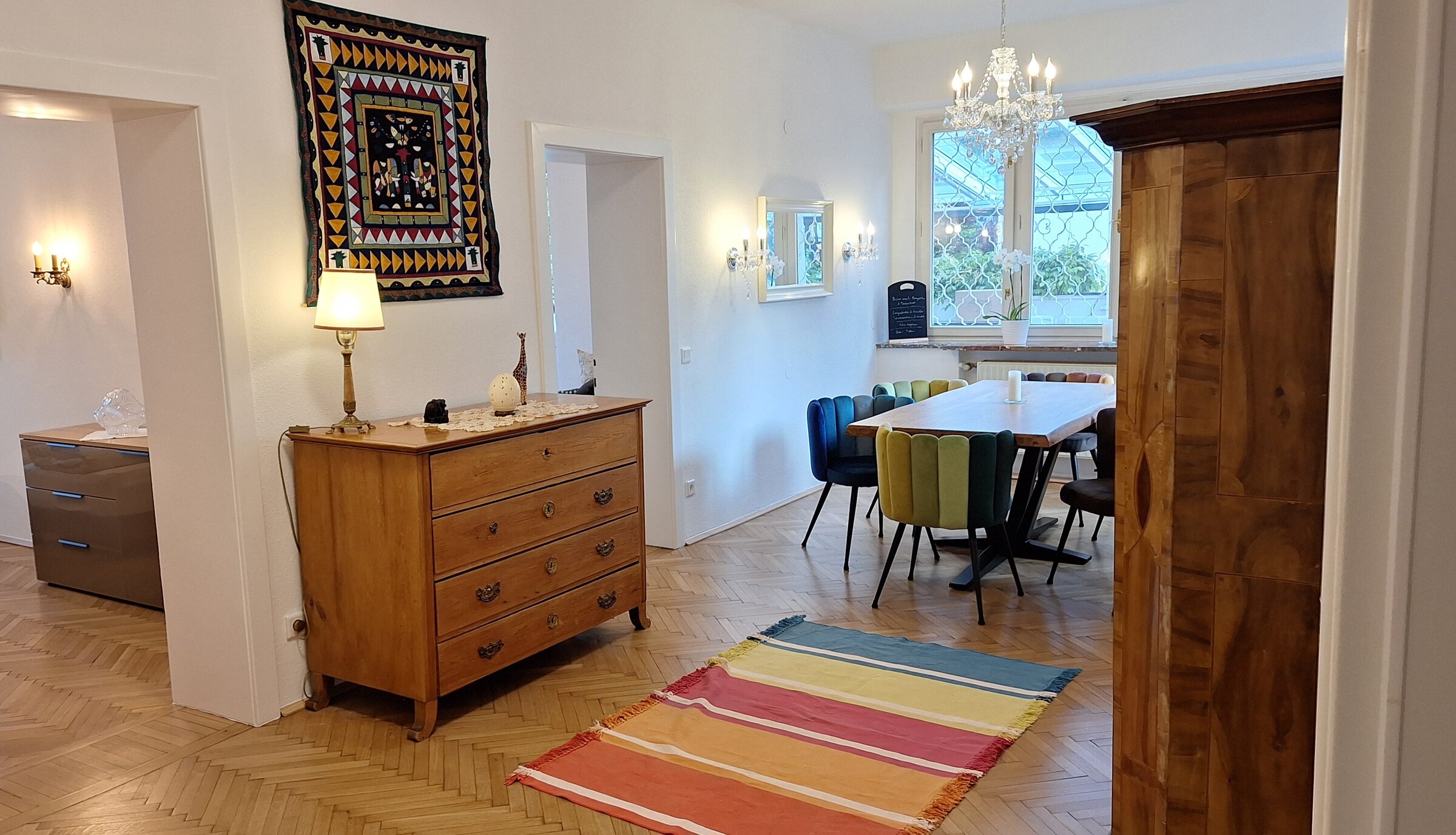 Bright living-dining room with herringbone parquet & chandelier – 4-room short-term rental, temporary housing Salzburg, 1–6 months
