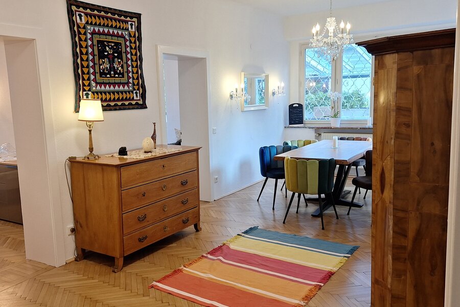 Bright living-dining room with herringbone parquet & chandelier – 4-room short-term rental, temporary housing Salzburg, 1–6 months