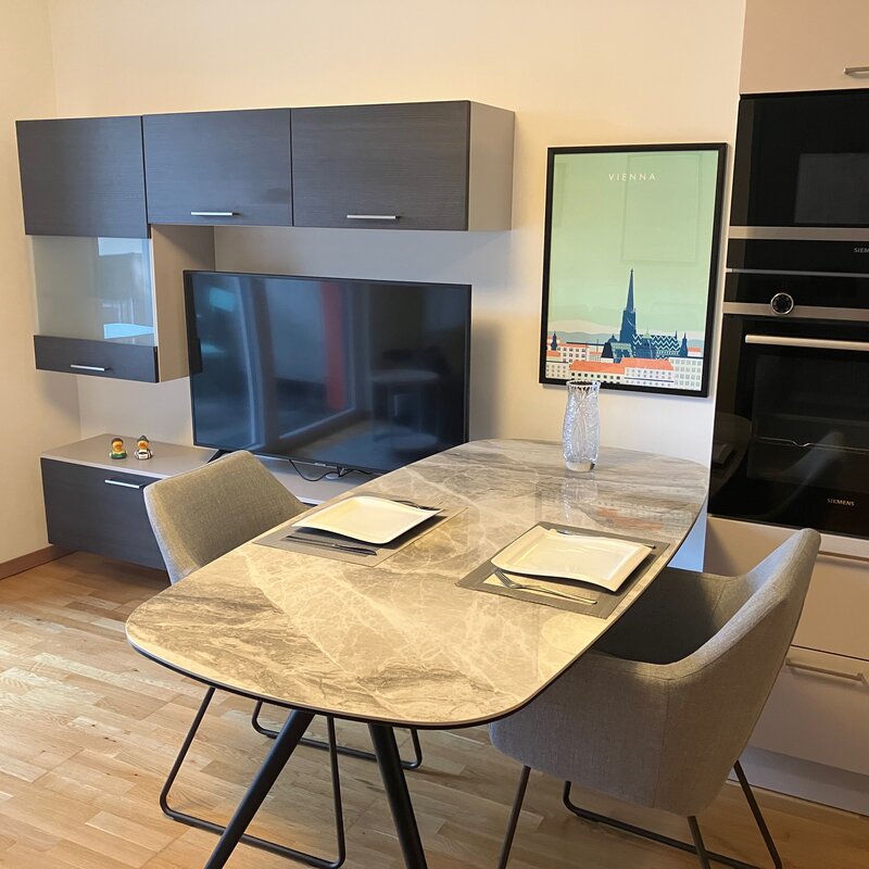 Moderner Wohn-Essbereich mit Marmortisch & Einbauküche – 2-Zimmer Wohnung zur Kurzzeitmiete in Wien
