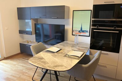 Moderner Wohn-Essbereich mit Marmortisch & Einbauküche – 2-Zimmer Wohnung zur Kurzzeitmiete in Wien