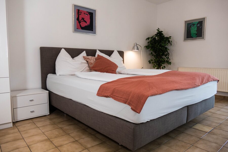 Bright bedroom with double bed & modern decor – 1-room apartment for short-term rental in Strass im Attergau