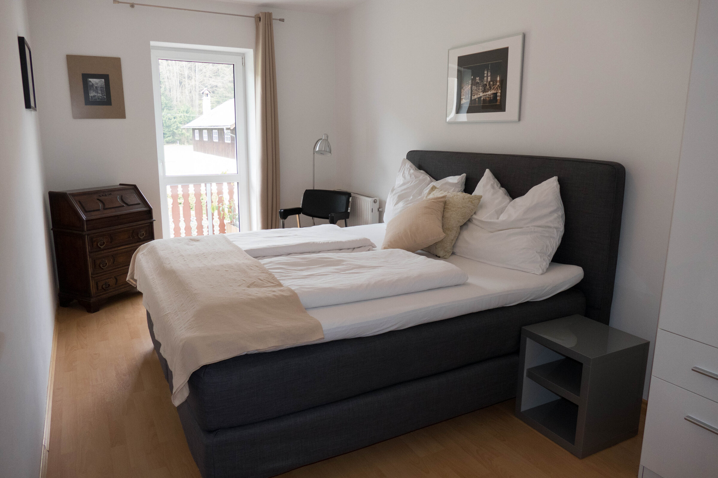 Cozy bedroom with double bed & wooden furniture – 2-room apartment for short-term rental in Strass im Attergau