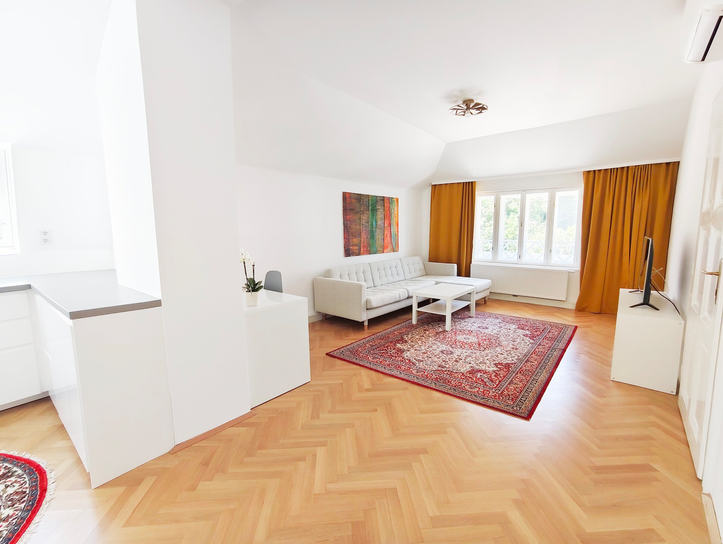Großzügiger offener Wohnraum mit integrierter Küche und Arbeitsplatz, rechts die Tür zum Schlazimmer.