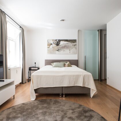 Helles Schlafzimmer mit Doppelbett & TV – 1-Zimmer Wohnung zur Kurzzeitmiete, Wohnen auf Zeit 1 bis 6 Monate, Salzburg