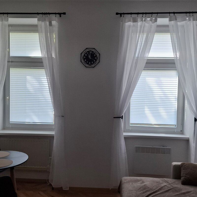 Helles Wohnzimmer mit großen Fenstern – 1-Zimmer Wohnung zur Kurzzeitmiete, Wohnen auf Zeit für 1 bis 6 Monate in Wien