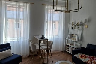 Bright living area with dining table & sofas – 1-room apartment for short-term rental & temporary housing for 1 to 6 months in Vienna