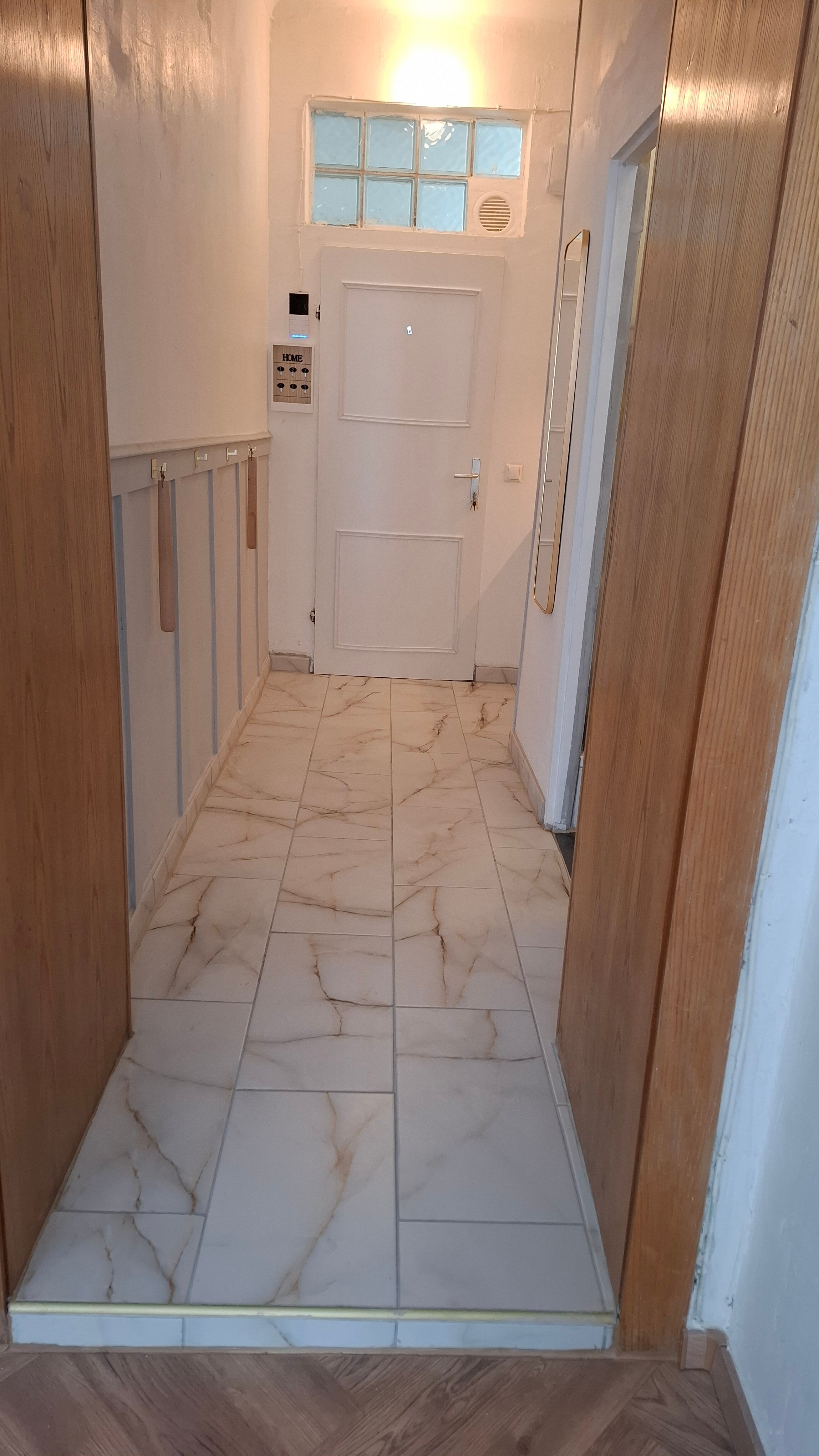 mit Eingangstür und Wandvertäfelung