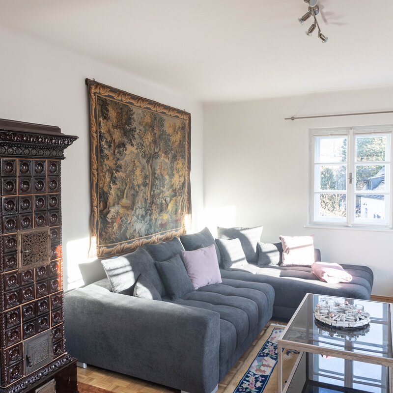 Wohnzimmer mit Kachelofen und Blick auf die Berge