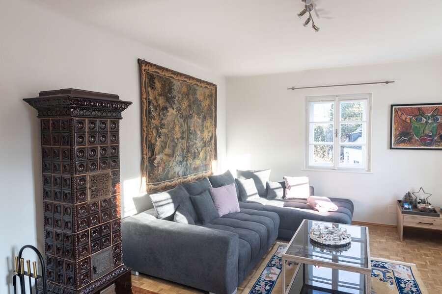 Wohnzimmer mit Kachelofen und Blick auf die Berge