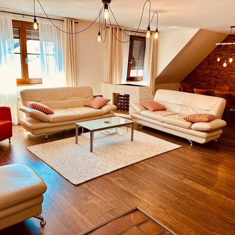 Großzügiger Wohnraum mit Esstisch und Kachelofen und Ofenbett.