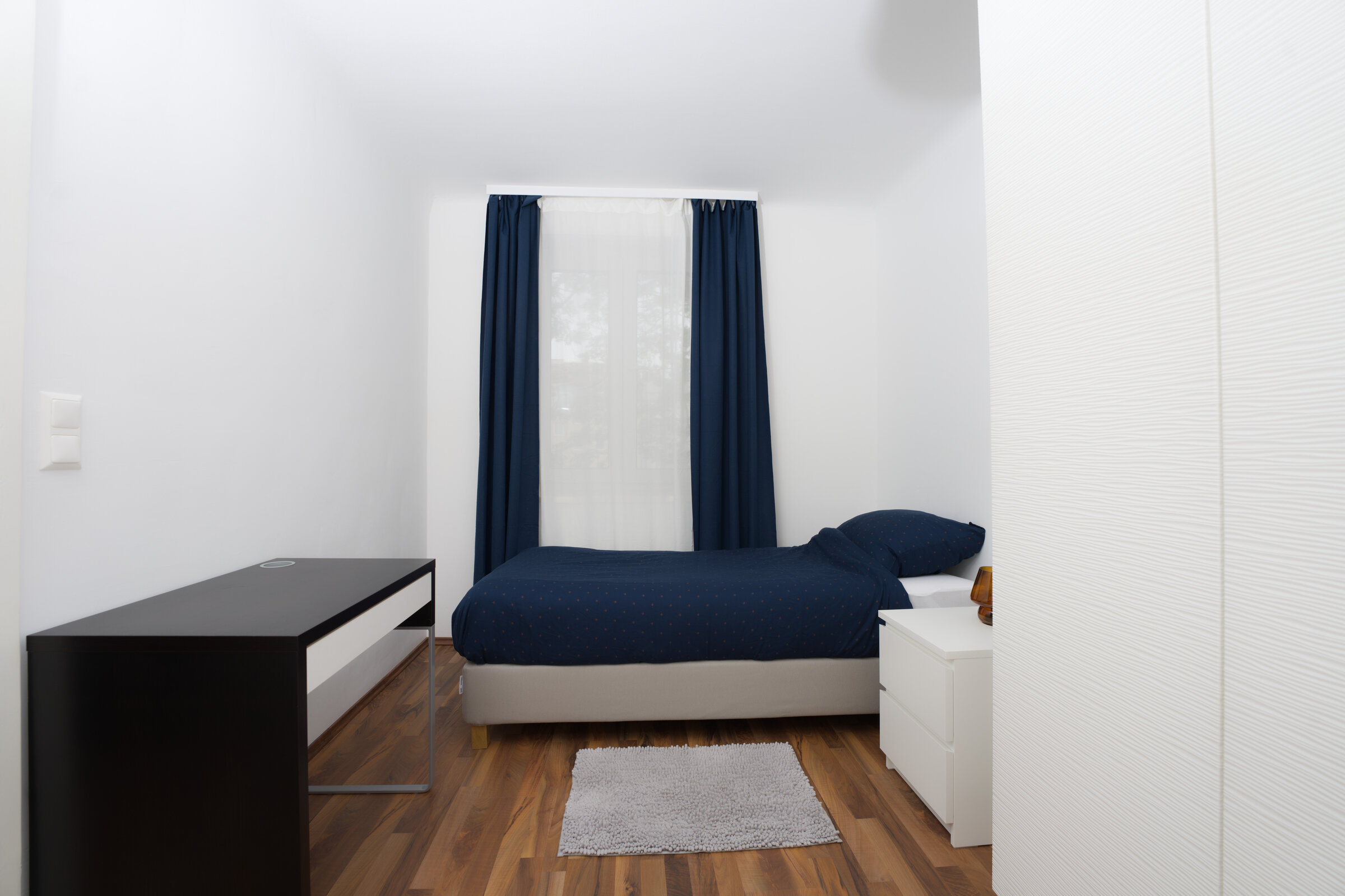 Schlafzimmer mit zwei Doppelbetten und Arbeitstisch 