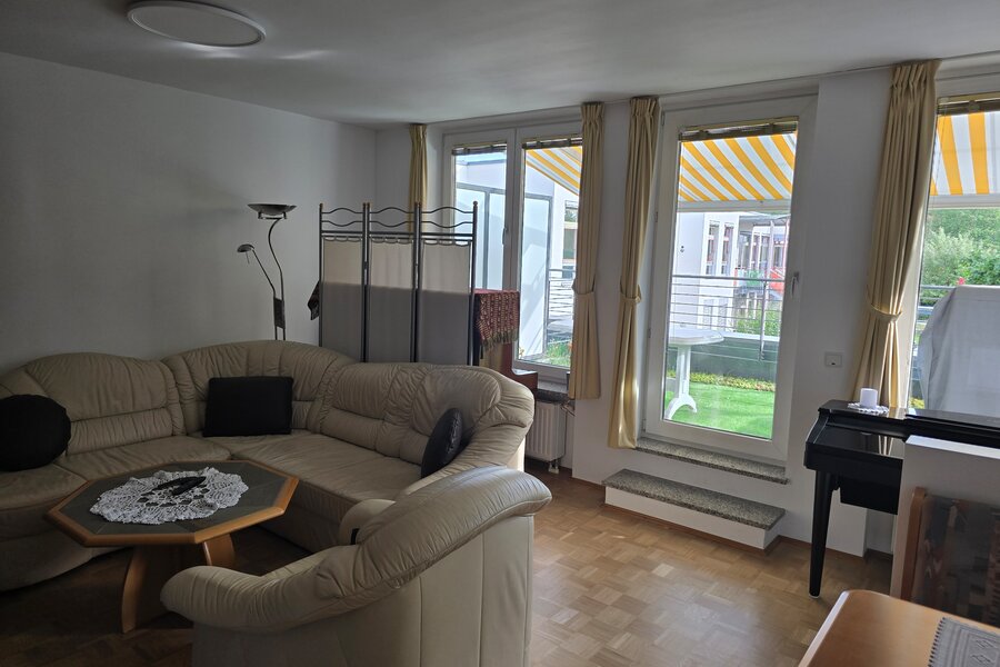 Heller und großzügiger Wohnbereich mit gemütlicher Sitzgruppe, bodentiefen Fenstern und direktem Zugang zur sonnigen Südterrasse sowie zur überdachten Loggia mit Süd-West-Ausrichtung. Der angrenzende Essbereich mit Eckbank lädt zu gemeinsamen Mahlzeiten ein. Der Raum ist lichtdurchflutet und bietet durch die Verbindung von Innen- und Außenbereich eine besonders wohnliche Atmosphäre. Warmer Parkettboden und liebevoll eingerichtete Details sorgen für ein behagliches Ambiente.