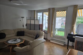 Heller und großzügiger Wohnbereich mit gemütlicher Sitzgruppe, bodentiefen Fenstern und direktem Zugang zur sonnigen Südterrasse sowie zur überdachten Loggia mit Süd-West-Ausrichtung. Der angrenzende Essbereich mit Eckbank lädt zu gemeinsamen Mahlzeiten ein. Der Raum ist lichtdurchflutet und bietet durch die Verbindung von Innen- und Außenbereich eine besonders wohnliche Atmosphäre. Warmer Parkettboden und liebevoll eingerichtete Details sorgen für ein behagliches Ambiente.