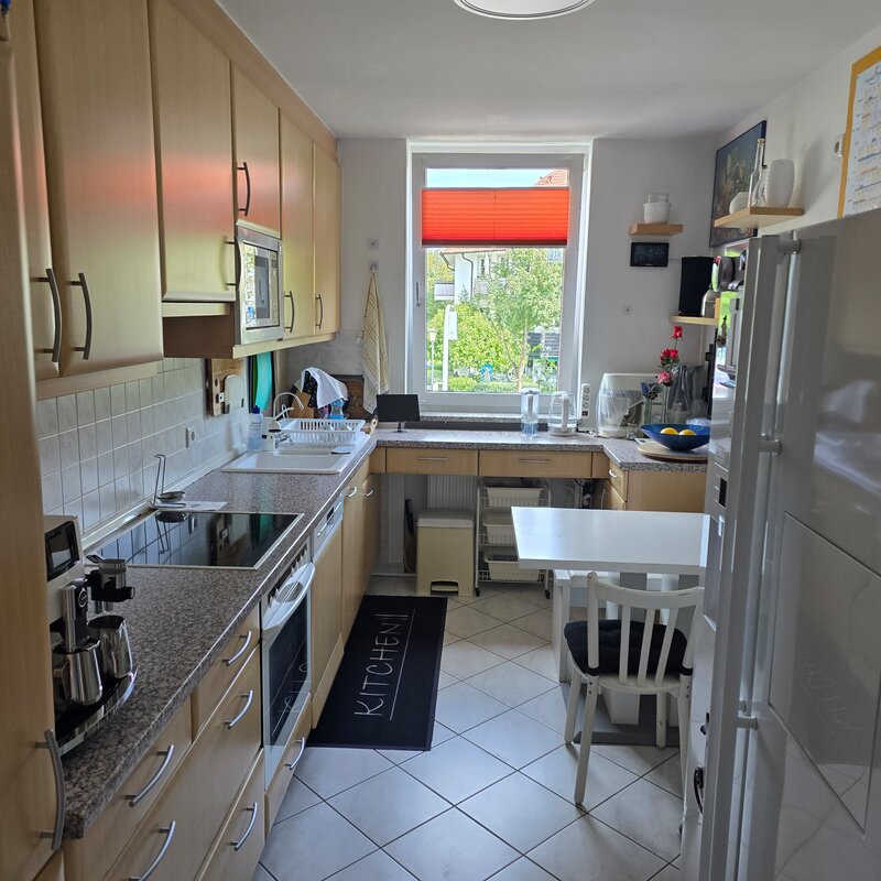 Die helle, gut ausgestattete Küche verfügt über zahlreiche Schränke, moderne Elektrogeräte (Cerankochfeld, Ofen, Mikrowelle), eine Doppelspüle und viel Arbeitsfläche.