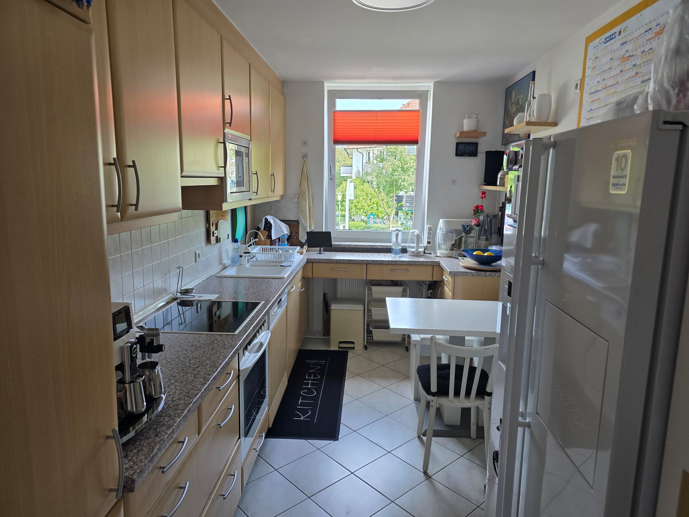 Die helle, gut ausgestattete Küche verfügt über zahlreiche Schränke, moderne Elektrogeräte (Cerankochfeld, Ofen, Mikrowelle), eine Doppelspüle und viel Arbeitsfläche.