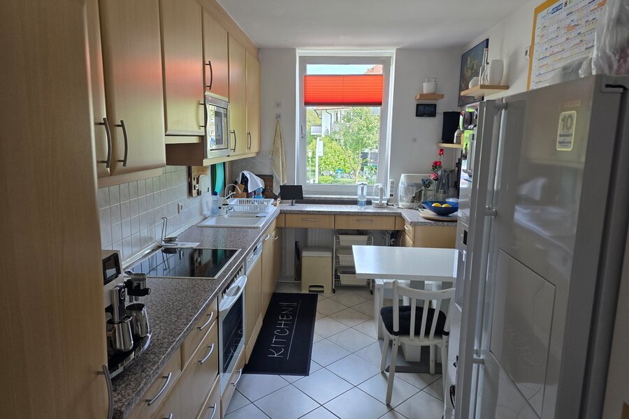 Die helle, gut ausgestattete Küche verfügt über zahlreiche Schränke, moderne Elektrogeräte (Cerankochfeld, Ofen, Mikrowelle), eine Doppelspüle und viel Arbeitsfläche.