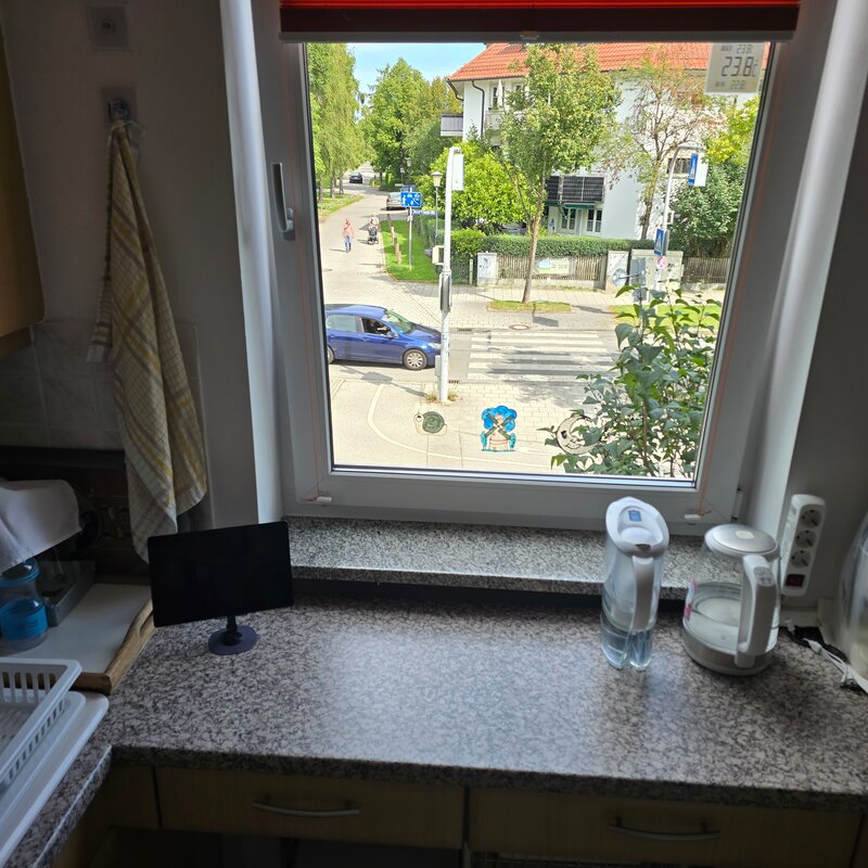 Der Blick aus dem Küchenfenster zeigt die ruhige Straße und grüne Umgebung - ideal zum Wohlfühlen in München-Feldmoching.
