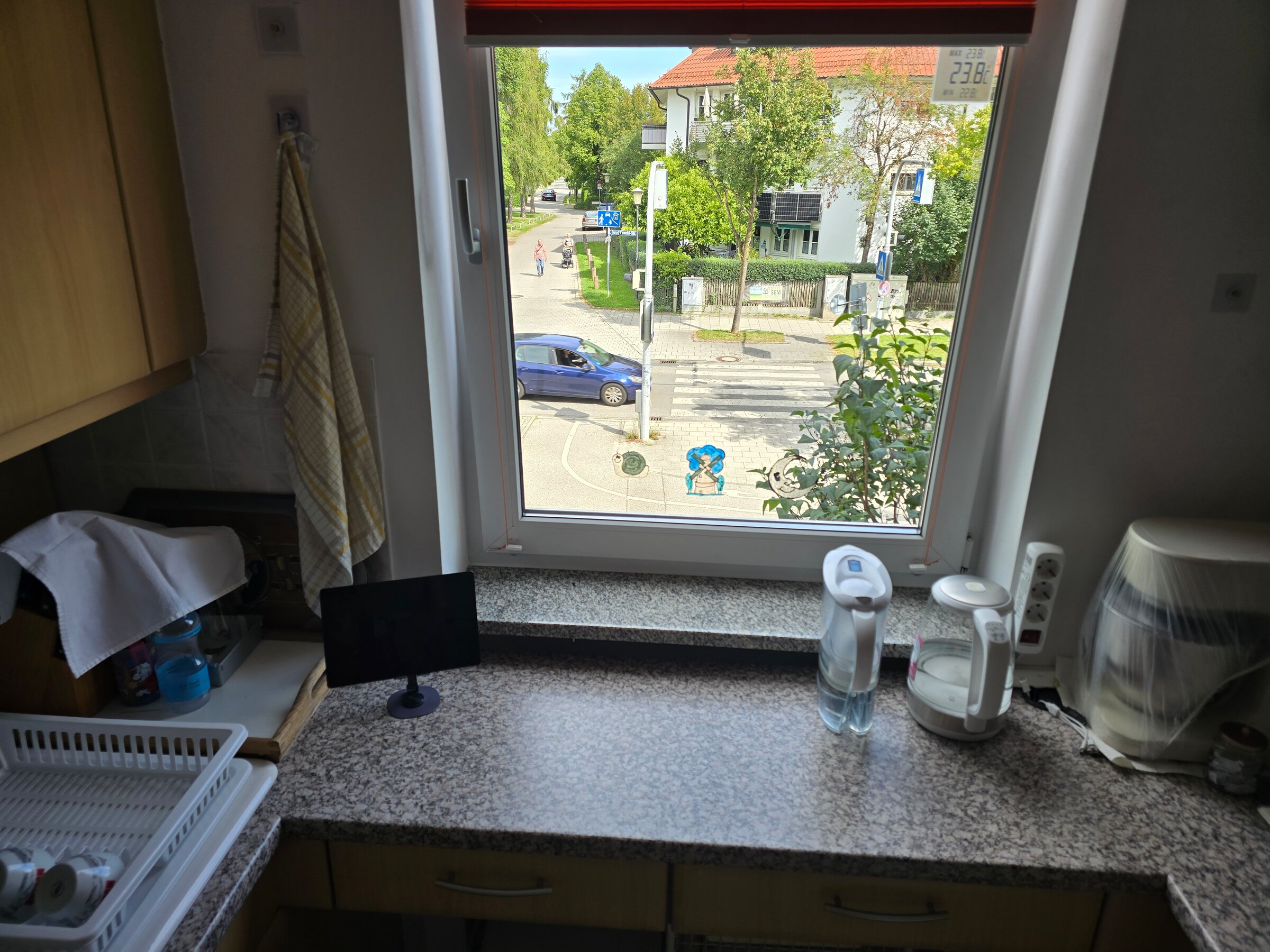 Der Blick aus dem Küchenfenster zeigt die ruhige Straße und grüne Umgebung - ideal zum Wohlfühlen in München-Feldmoching.