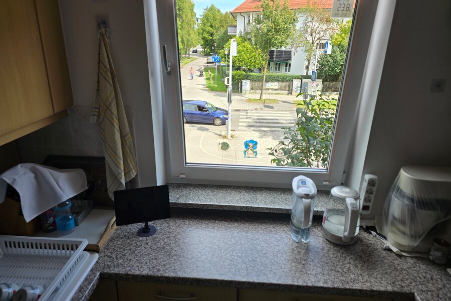 Der Blick aus dem Küchenfenster zeigt die ruhige Straße und grüne Umgebung - ideal zum Wohlfühlen in München-Feldmoching.