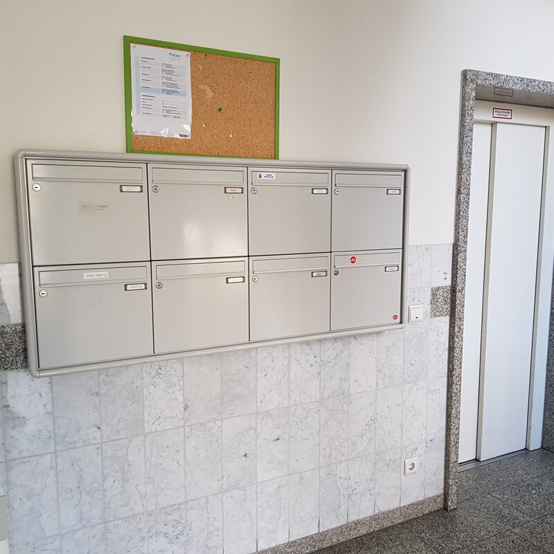 Ordentlicher Eingangsbereich mit Briefkastenanlage und Aufzug im Erdgeschoss des Mehrfamilienhauses.