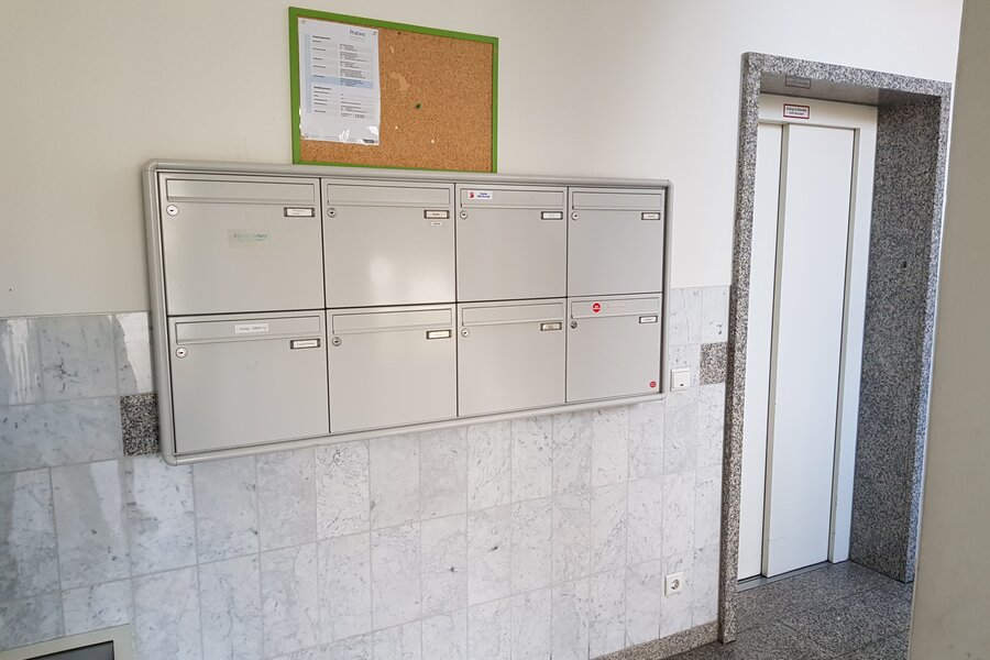 Ordentlicher Eingangsbereich mit Briefkastenanlage und Aufzug im Erdgeschoss des Mehrfamilienhauses.
