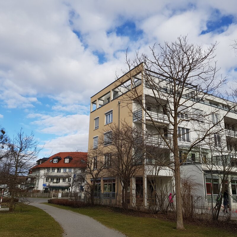 Blick auf die Südseite der Wohnung mit eigener Loggia und Zugang zur begrünten Terrasse - ideal zum Entspannen.